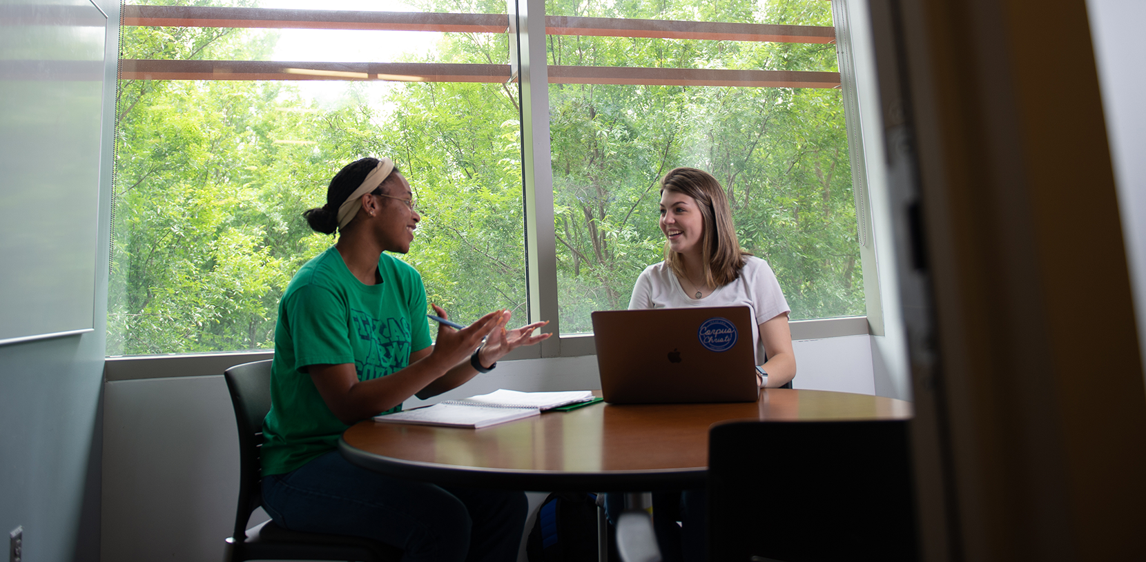 students sitting by a window and talking
