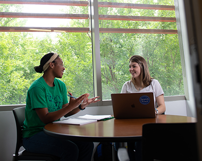 students sitting by a window and talking